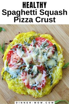 a pizza with spinach, tomatoes and cheese is on a cutting board next to the words healthy spaghetti squash pizza crust