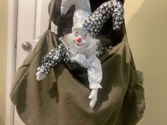 a stuffed animal in a bag hanging on a door