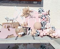 a table topped with balloons and animals on top of a table next to a building