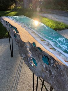 a table made out of wood and glass with the sun shining on it's surface