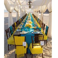 a long table is set up with blue and yellow linens for an ocean themed dinner