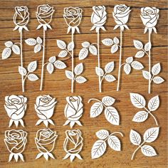 paper cut out roses sitting on top of a wooden table