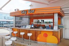 an orange and white sky bar with stools