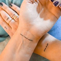 two women with matching tattoos on their arms, both holding each other's hands