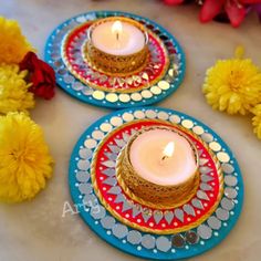 two plates with candles on them sitting next to yellow flowers and red, white, and blue plates