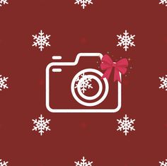 a camera with a bow on it is surrounded by snowflakes