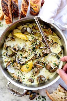 a pan filled with clams and bread on top of a table