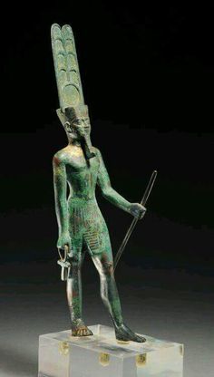 an ancient statue with a spear and headdress