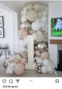 the balloon arch is decorated with white and pink balloons, silver and gold balloons, and a number one