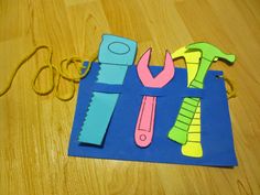 paper cut out of construction tools sitting on top of a wooden table