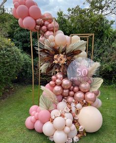 the balloon arch is decorated with pink, gold and white balloons for a 50th birthday party