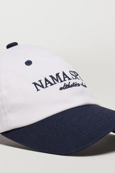 Description Crafted from cotton canvas, this cap features a timeless two-tone finish and an embroidered logo, making it a must-have for your off duty look. 100% cotton twill fabric Adjustable back strap Matte nickel buckle 6 panel Unisex fit 'NAMA SPORT' logo embroidery Complete the look: Body Butter™ Crop Jacket Fabric & Fit 100% Cotton Adjustable fit Model is 5'9", 36" Bust, 28" Waist, 42" Hips, and wears a size small top and medium bottom. Shipping & Returns Visit our Shipping and Returns pag Cotton Baseball Cap With Logo, Cotton Six-panel Hat With Logo, Cotton Snapback Hat With Embroidered Logo Visor, Cotton Baseball Cap With Curved Brim And Logo, Cotton Snapback Hat With Embroidered Logo, Cotton Snapback Visor Hat With Embroidered Logo, Cotton Visor Snapback Hat With Embroidered Logo, Classic Cotton Dad Hat With Logo, Navy Cotton Hat With Logo Patch