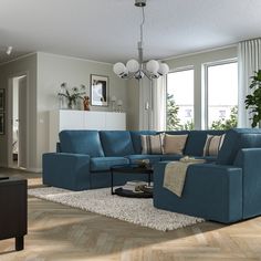 a living room with blue couches and white rugs on the wooden flooring