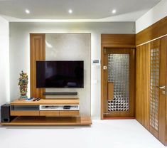 a flat screen tv sitting on top of a wooden stand in front of a doorway