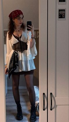 a woman is taking a selfie in the mirror while wearing a pirate corset