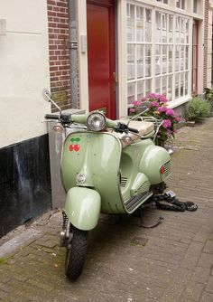 a green scooter parked in front of a building