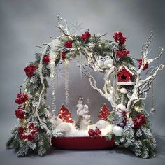 a christmas display with ornaments and decorations on the top, in front of a gray background