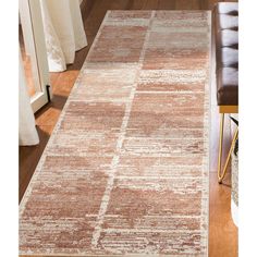 a brown and white area rug in a living room with a chair next to it