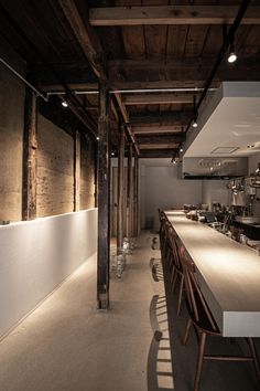 an empty restaurant with long counter tops and bar stools in the middle of the room