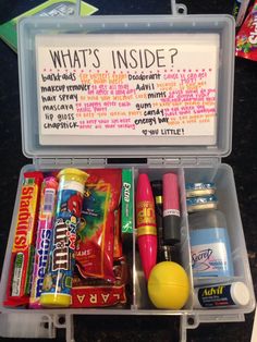 an open lunch box with candy, candies and other items in it that are labeled what's inside?