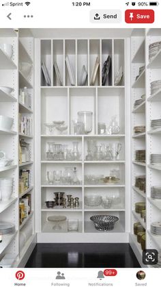 an organized pantry with white shelves filled with dishes