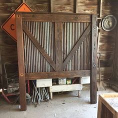 an old barn has a wooden gate with metal slats on it and a sign that reads c