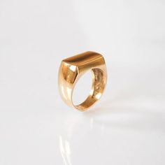 a gold ring sitting on top of a white surface