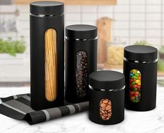 three black canisters with candy in them