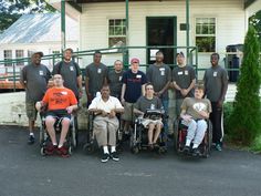 a group of people standing and sitting in front of a house