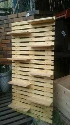 wooden pallets stacked on top of each other in front of a brick wall and fence