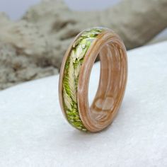 a ring made out of wood with green leaves on the inside and inlays