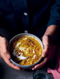 a person holding a bowl of food in their hands