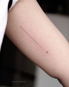 a person's arm with a tiny star tattoo on the left side of their arm