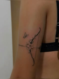 a woman's arm with a flower and arrow tattoo on the left side of her right arm