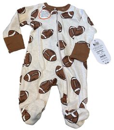 This Football Print Footed Pajamas in size 0-3 months is an adorable one-piece outfit perfect for little boys in the winter and fall seasons. The long sleeve pajama features a zip closure for easy dressing, snap collar accents, and hand covers to keep baby warm. Made of cozy fleece fabric with a football theme, this machine washable garment in white polyester is ideal for young sports enthusiasts and is brand new with tags. Perfect for keeping your little one snug and stylish during the cooler months. Football Themes, One Piece Outfit, Baby Warmer, Baby & Toddler Clothing, Long Sleeve Pyjamas, Simple Dresses, Fleece Fabric, Toddler Outfits, Baby Accessories