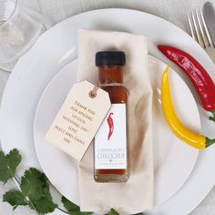 a bottle of chili sauce sitting on top of a white plate next to a red pepper