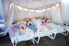 a bed with pillows and lights on the headboard is decorated in pastel colors