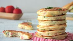 a stack of pancakes sitting on top of a red and white checkered table cloth