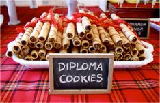 there is a sign that says diploma cookies in front of some other items on the table