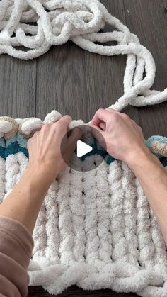 a person is working on a rug with yarn