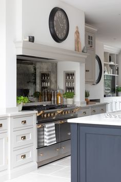 a kitchen with an oven, sink and clock on the wall