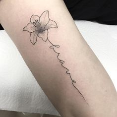 a woman's leg with a flower tattoo on the left side of her arm