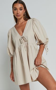 Turn heads in our Rosita Mini Dress! This tie front puff sleeve dress in stone is the perfect addition to your casual weekend activities. Made from comfortable cotton, this V-neck mini dress features 3/4 sleeves for a chic and stylish look. Its neutral color makes it easy to pair with any accessories or shoes, giving you endless options for creating different outfits. Whether you're meeting friends for brunch or running errands around town, the Rosita Mini Dress will keep you looking effortlessl Beige V-neck Cotton Mini Dress, Beige Cotton V-neck Mini Dress, Cotton V-neck Puff Sleeve Dress For Brunch, Brunch Dress Outfit, Doc Fits, Nursing Outfits, Outfits For Spain, Linen Casual Dress, Brunch Dress