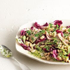 a white plate topped with salad and beans