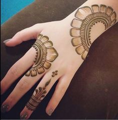 a woman's hand with henna tattoos on it