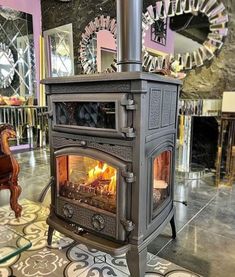 an old fashioned stove is in the middle of a room with tile flooring and rugs