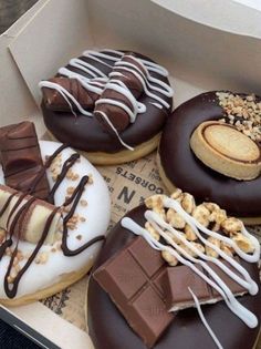 a box filled with lots of different types of doughnuts on top of each other