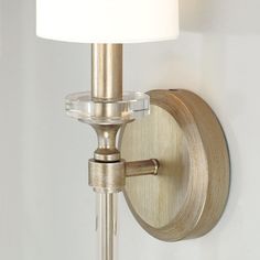 a wall light with a white shade on it's side and a metal arm