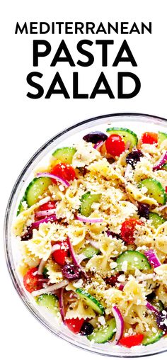 a salad with cucumbers, tomatoes, onions and cheese in a glass bowl