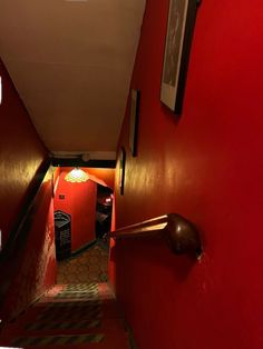 an empty hallway with red walls and stairs